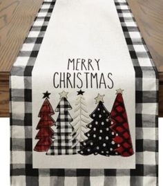 a black and white christmas table runner with three trees on the front, merry christmas