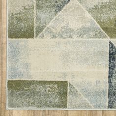 an area rug with various colors and shapes on it, including blue, green, white and beige