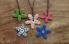 four different colored flowers are on a wooden table and one is painted red, white, and blue