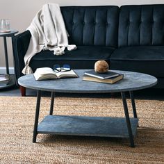 a living room with a couch, coffee table and books on the end tables in front of it