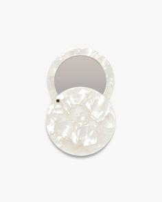 an oval shell shaped mirror on a white background