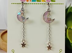 These lovely earrings are perfect for the astrology lover in your life!  Each charm is made from resin dyed in pastel colors with a splash of glitter poured into a tiny metal frame, then the details are hand painted before the whole thing is sealed in a layer of clear resin to protect the mini work of art!    Earrings measure around 2 inches in length with stud findings. Findings are nickel and lead free. Please remove from wearing before swimming or showering. *Note- Hand crafted resin pieces usually have small flaws such as air bubbles. I try to limit these as much as possible and most will be unnoticeable. These flaws won't cause any damage to the piece and are no cause for concern, but they're part of what makes handmade resin pieces unique and one of a kind! Moon Phase Star Earrings For Gift, Adjustable Kawaii Dangle Earrings, Silver Dangle Kawaii Jewelry, Magical Nickel-free Earrings For Gifts, Nickel-free Magical Earrings For Gift, Whimsical Moon Charm Earrings Gift, Silver Hypoallergenic Kawaii Earrings, Hypoallergenic Silver Kawaii Earrings, Handmade Space-themed Earrings For Gift