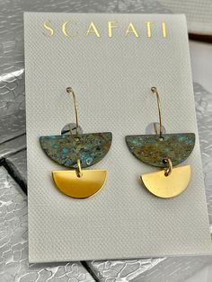 "The half circles are brass rack plated with 18 K gold and hand done in patina. The patina is done primarily in earthy tones of turquoise and rust. The hoops are gold plated with 24 K gold. The length is 1 1/4\" from the top of the hoop down. All metals used are lead safe." Green Minimalist Brass Earrings, Minimalist Green Brass Earrings, Modern Gold Nickel-free Earrings, Modern Gold Nickel-free Linear Earrings, Modern Adjustable Gold Earrings, Modern Bronze Earrings With Ear Wire, Modern Gold Brass Hoop Earrings, Modern Bronze Earrings As Gift, Modern Gold-tone Brass Earrings