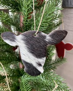 a cow ornament hanging from a christmas tree