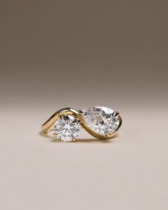 two pear shaped diamond engagement rings in yellow gold