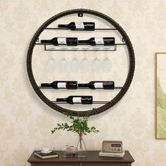 a wall mounted wine rack with bottles and glasses on it in front of a table