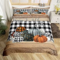 a bed covered in black and white checkered sheets with pumpkins on the cover