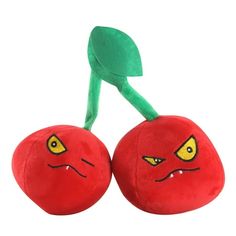 two stuffed cherries with green stems and yellow eyes, one has an angry look on its face