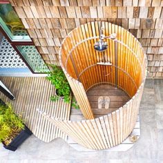 an aerial view of a wooden structure in the middle of a courtyard with potted plants