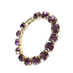 This vintage women's tennis bracelet showcases a 14+ carat purple amethyst gemstone, which has been lab-created and is perfectly round in shape. The gemstone is set in a gold tone metal with slight signs of wear, stone with minor loss,, but is still in overall good condition. Measuring 6.75 inches in length and 0.25 inches in height. Anniversary Amethyst Gemstone Tennis Bracelet, Purple Jewelry With Jubilee Bracelet For Anniversary, Purple Round Bracelets For Anniversary, Purple Round Stone Jewelry For Formal Occasions, Purple Tennis Bracelet For Anniversary, Classic Amethyst Bracelets In Purple, Classic Amethyst Purple Bracelets, Amethyst Tennis Bracelet As A Gift, Adjustable Purple Jewelry With Sparkling Stones