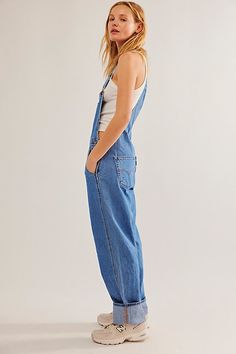 The perfect vintage-inspired overalls from Levi's, this distressed style is featured in a classic bib-and-brace silhouette with front pouch pocket and relaxed, straight leg design. * Adjustable straps * Four pocket design * Side button closures * Logo patch detail at front | Levi's Vintage Overalls at Free People in Medium Wash, Size: XL