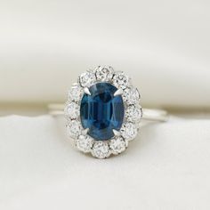 an oval shaped blue sapphire surrounded by white diamonds