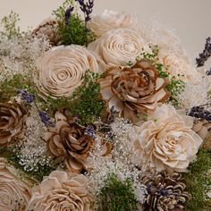 a bouquet of flowers with pine cones and baby's breath