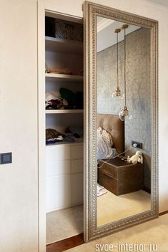 a large mirror sitting in the middle of a room next to a closet filled with clothes