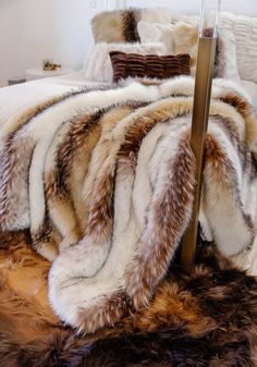 a bed covered in furry blankets and pillows