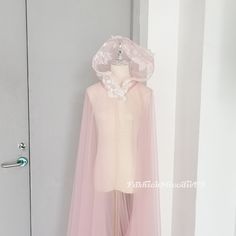 a mannequin wearing a pink dress and bonnet in front of a white door