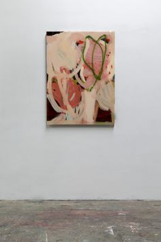 an abstract painting hanging on the wall next to a white wall with a plant in it