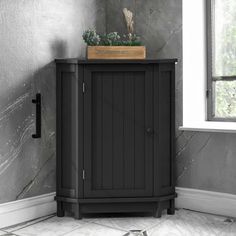 a corner cabinet with a potted plant on top in front of a gray wall