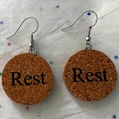 two cork earrings with the word party printed on them