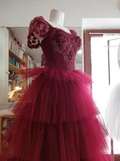 a red dress is on display in front of a mannequin's head