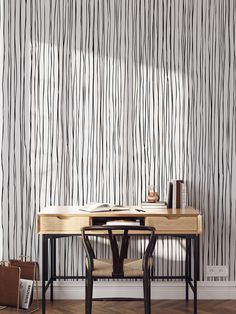 a desk and chair in front of a wall with black lines on the wall behind it