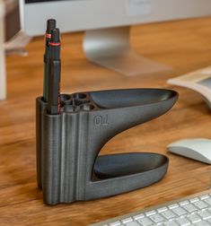 a desk with a keyboard, mouse and pen holder