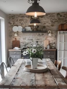 a wooden table topped with flowers in a kitchen