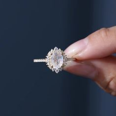 a woman's hand holding an engagement ring with a large white diamond in the center