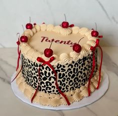 a decorated leopard print cake with cherries on top and the word twenty written on it