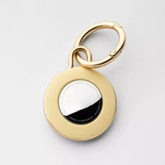 a gold keychain with a black and white circle on it