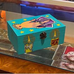 a blue box with candles on it sitting on top of a glass table next to other items