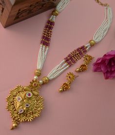 This beautiful antique gold pendant features Kemp stones and American diamonds, paired with a Pearl Mala Necklace and earrings set. This exquisite necklace enhances your style for any occasion, adding sparkle whether you wear it with a dress or a stunning saree. Necklace Length: 11.5" and can be adjusted with a chain. Earring length: 1.5" with push-back closure Antique gold Polish and High-quality brass as the base metal Availability: In-Stock. *Color may vary slightly due to light condition & p Elegant Zari Work Jewelry For Puja, Elegant Kundan Necklace With Zari Work For Puja, Elegant Bridal Necklace With Zari Work For Puja, Elegant Kundan Necklace For Puja And Festive Occasions, Elegant Dual-tone Temple Necklace For Puja, Dual-tone Elegant Jewelry For Puja, Elegant Dual-tone Jewelry For Puja, Elegant Gold Plated Bridal Necklace For Puja, Elegant Temple Necklace For Puja With Stone Work