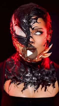 a woman with black and red makeup wearing a creepy mask