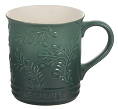 a green coffee mug with leaves on it