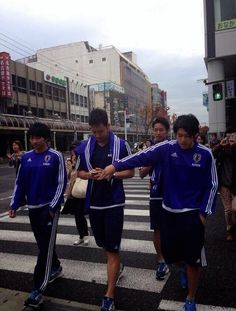 several young men walking across a cross walk