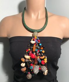 "Immerse yourself in the rich tapestry of African culture with our handmade necklace. Crafted with meticulous detail, this piece showcases traditional craftsmanship, vibrant colors, and intricate beadwork. Each bead tells a story, making this necklace not just an accessory but a cultural statement. Embrace the spirit of Africa and adorn yourself with a unique piece that reflects heritage and style. Perfect for those who appreciate the artistry and diversity of African jewelry." Material: Glass b Green Multi-strand Beaded Necklaces For Festivals, Green Multi-strand Beaded Necklace For Festival, Hippie Style Green Beaded Necklace For Festivals, Handmade Green Bohemian Beaded Necklaces, Bohemian Multi-strand Green Beads, Hippie Style Green Beaded Necklaces With Round Beads, Bohemian Green Multi-strand Beads, Handmade Green Beaded Necklaces For Festivals, Green Multi-strand Festival Necklaces