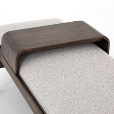 a close up of a wooden bench with fabric on the back and seat cushioning