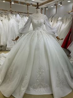 a white wedding dress is on display in a store with other gowns behind it