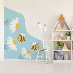 a child's room decorated in blue and white with flowers on the wall next to a book shelf