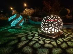 two large balls sitting on top of a lush green field