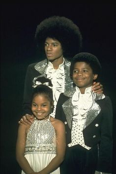 the jacksons posing for a photo in their disco outfits