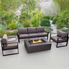 a fire pit sitting on top of a patio surrounded by furniture