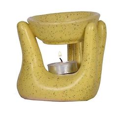 a small yellow candle holder with a lit candle in it