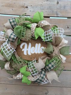 a green and white wreath with the word hello on it sitting on a wooden surface