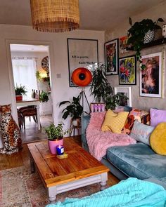 a living room filled with furniture and lots of plants on top of the tables in front of them