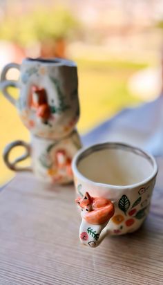 two coffee cups sitting on top of a wooden table