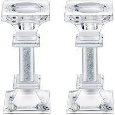 two clear glass candlesticks with silver glitter on each candle holder and the top one is turned upside down