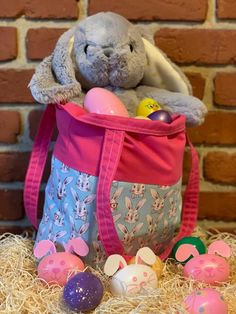 a stuffed animal sitting in a bag filled with eggs and other toys next to a brick wall