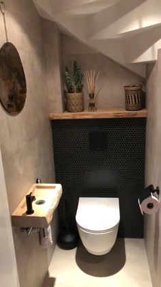 a bathroom with a toilet, sink and mirror in it's corner area on the wall