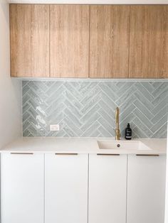 a kitchen with wooden cabinets and white counter tops, along with a gold faucet